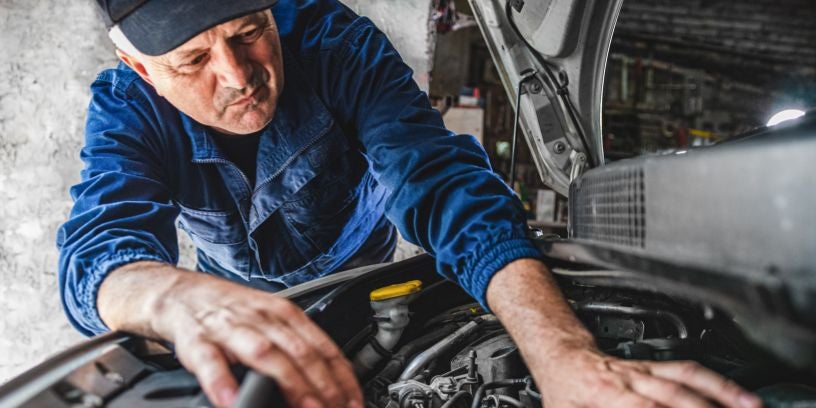 Mechanic fixing car engine